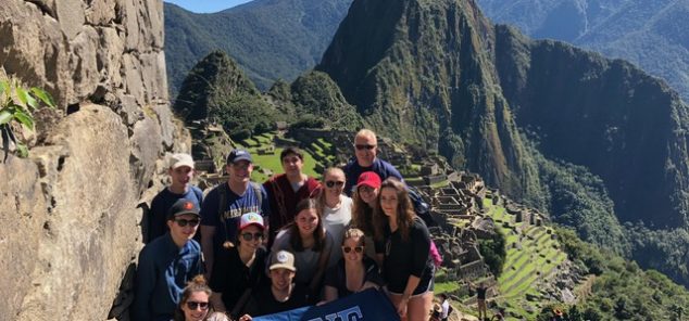students in mountains of Peru with UMaine banner