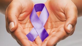 hands holding a purple awareness ribbon