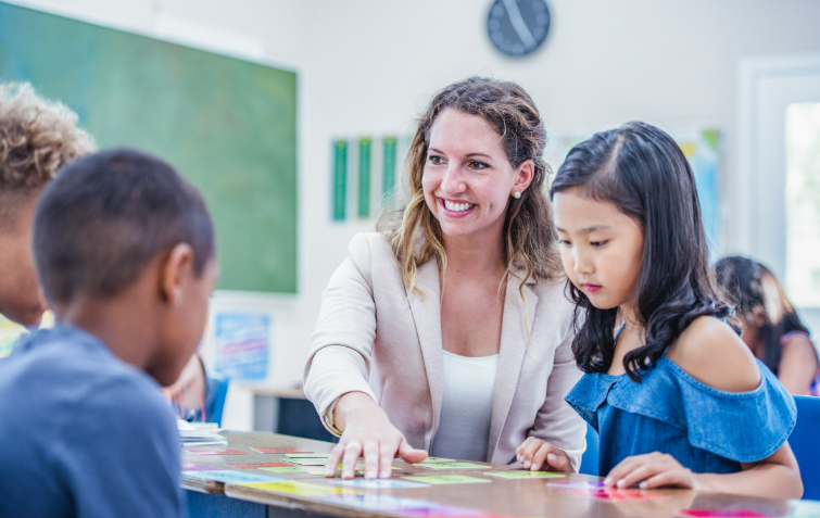 teacher sitting at table with children