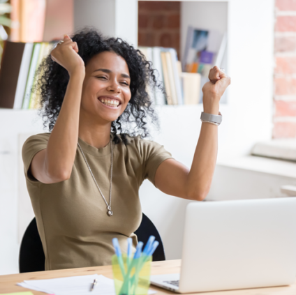 person at laptop with their hands up in excitement