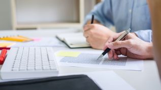 Tutor books with friends, person sitting pointing studying together at desk with classmates exams, hands with books or textbooks writing to notebooks, learning, education and school concept