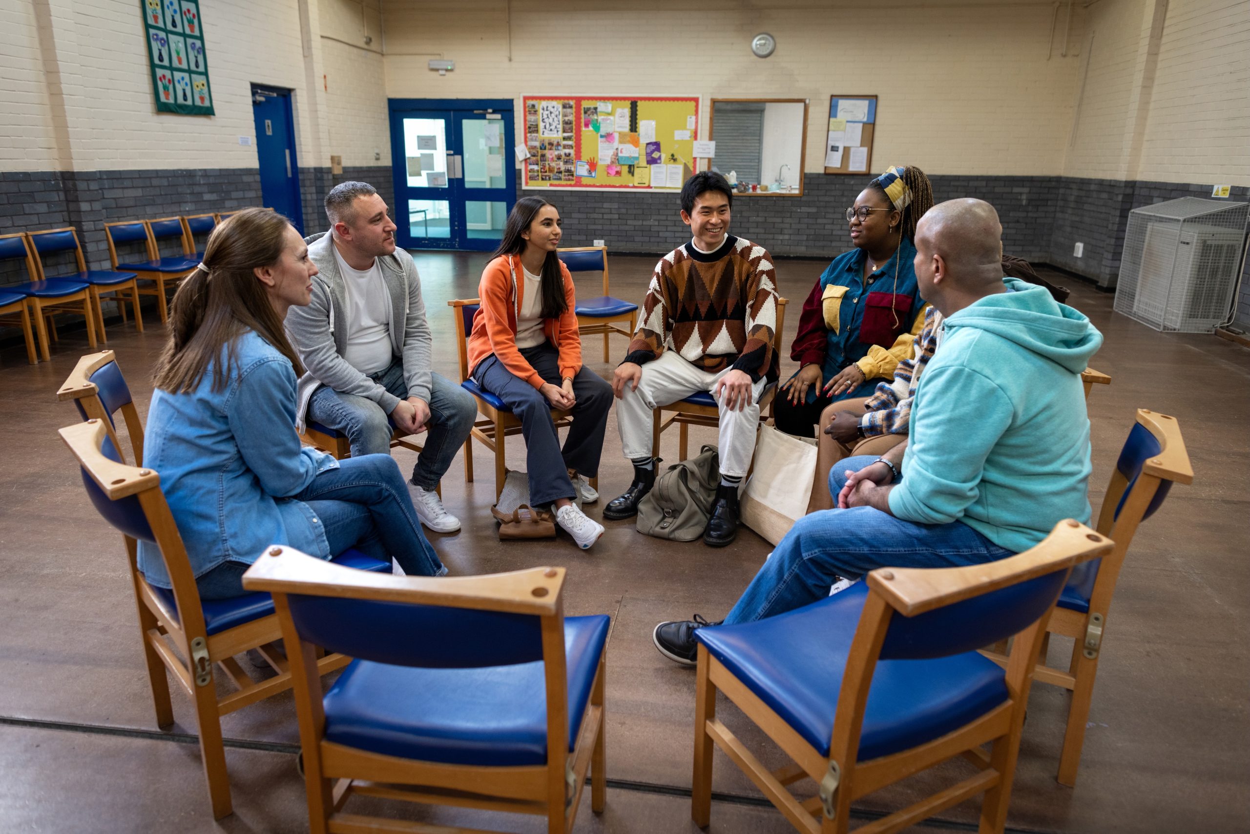 A group of people sitting in a circle in a community center
