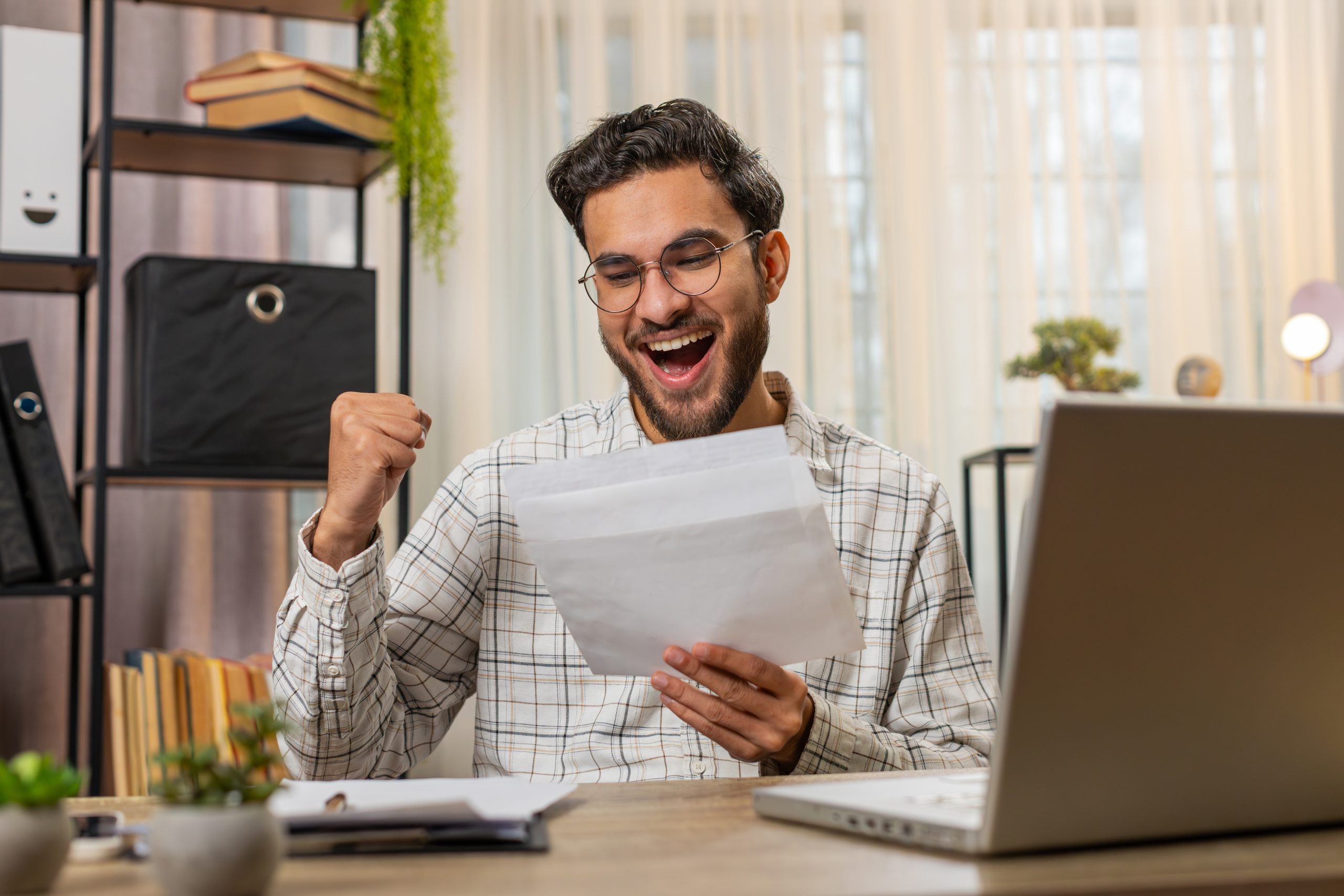 Person expressing excitement while looking at a piece of paper