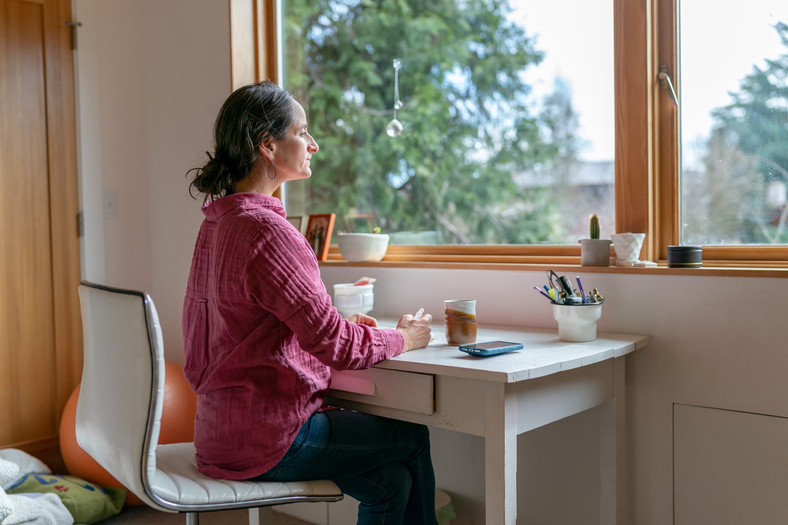 Person sitting reflectively at their desk